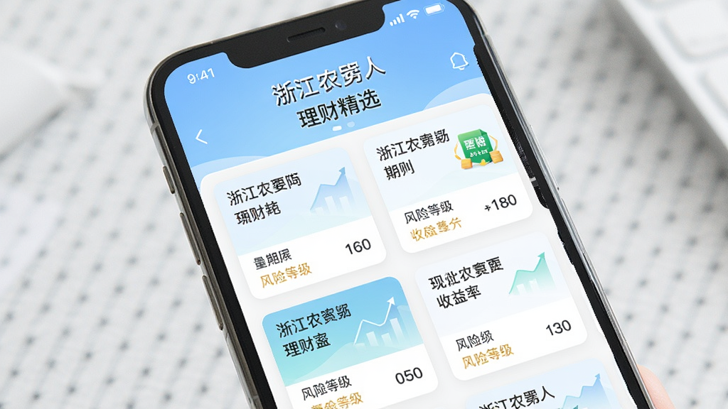 画面主体为手机屏幕展示浙江农商人理财超市页面,包含多个理财产品卡片,显示产品名称、期限、收益率、风险等级。布局为网格排列,风格为清新金融风,配色柔和,细节丰富,高画质,干净,无多余元素,屏幕中文字“浙江农商人”“理财精选”。