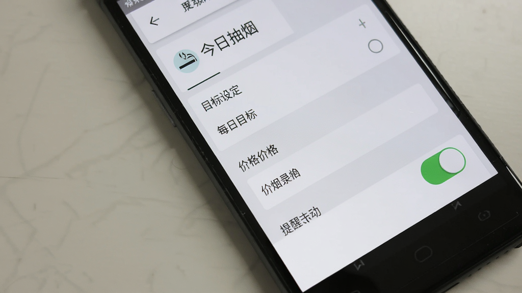 一部安卓手机显示“今日抽烟”应用设置界面,画面中包含目标设定选项、价格录入框和提醒开关,界面风格简洁,配色以白色和浅灰色为主,布局清晰,画质干净,无多余元素,文字为中文“今日抽烟”“每日目标”“香烟价格”