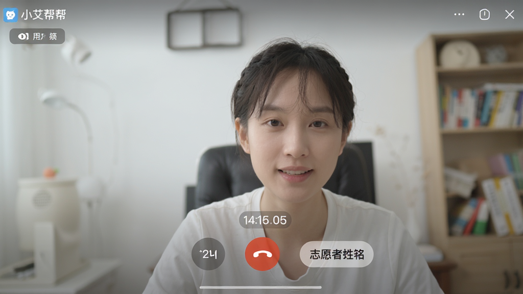 画面主体是“小艾帮帮”软件的用户界面截图,展示视频通话进行中的场景。布局为全屏视频画面叠加半透明操作按钮。排版简洁,风格真实。细节包括清晰的视频画面、通话时长显示、挂断按钮、志愿者姓名标签。画质高清,画面干净,无多余元素。