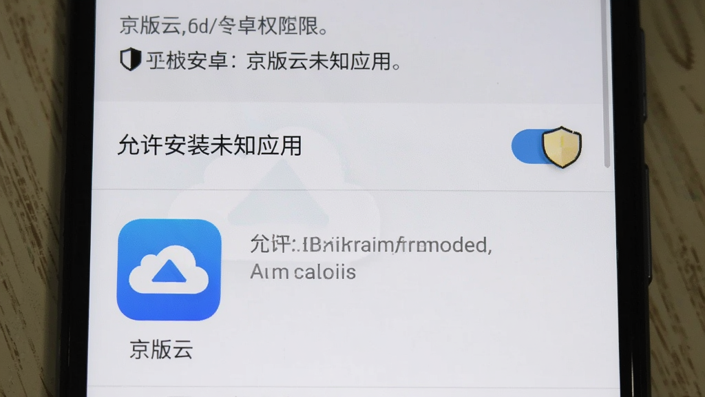 京版云安卓手机安装权限设置界面,手机屏幕显示“允许安装未知应用”开关按钮,下方有“京版云”应用图标,背景为系统设置页面,风格原生安卓,细节包含安全提示文字、盾牌图标,画质清晰,干净无多余元素