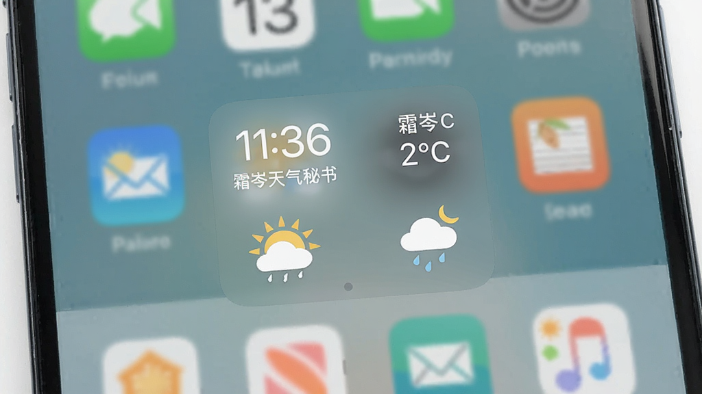 一张展示霜岑天气秘书桌面小组件的手机桌面图,主体为手机屏幕,布局为桌面网格,中间放置天气小组件,风格清爽素雅,细节包含时间、日期、温度、天气图标、半透明背景,画质高清,干净,无多余元素