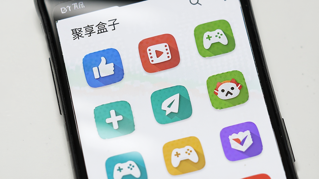 一部安卓手机屏幕中展示“聚享盒子”应用分类页面,页面内排列着社交、影音、工具、游戏等多个彩色分类图标,图标整齐排列为网格状,背景干净简洁,画面风格清爽明快,细节清晰,画质干净,无多余元素