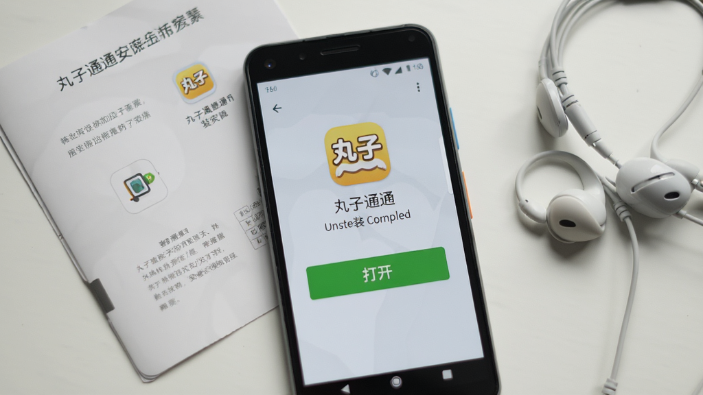 画面主体为一部安卓手机屏幕显示丸子通通应用安装完成界面,界面中有「打开」按钮,背景为浅灰色,手机旁边放着说明书和耳机,风格生活化,细节清晰,画质干净,无多余元素,高分辨率。