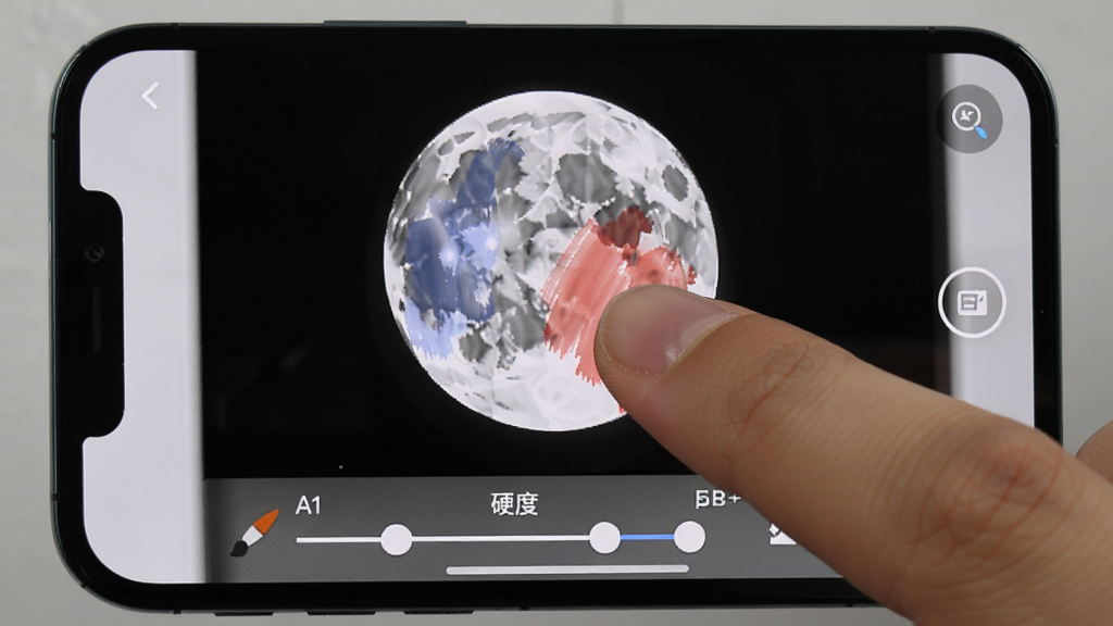 月影黑白移动端操作界面截图,画面显示手机屏幕上正在使用局部色彩功能,手指触摸屏幕进行涂抹操作,画面中黑白背景与彩色区域对比明显,界面底部有画笔大小和硬度调节滑块,风格为真实手机操作场景,细节包括手指触控和界面元素,画质高清,干净,无多余元素