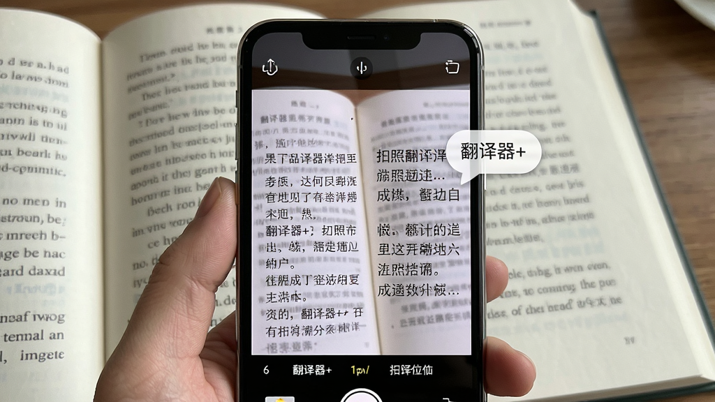 主体为“翻译器+”拍照翻译功能演示,手机摄像头对准一本英文书籍页面,屏幕上叠加显示中文翻译结果;布局采用第一人称视角,手机位于画面中央;排版展示原文与译文同屏对照;风格为增强现实感演示图;细节包括书本纸张纹理、手机边缘反光、翻译文字气泡;画质高清,干净无多余元素。