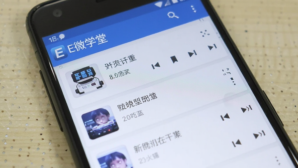 一张展示E微学堂在安卓手机上正常运行的界面截图,画面中手机屏幕显示听力播放列表,顶部有“E微学堂”标识,背景为浅色桌面,整体风格真实自然,画质清晰,干净无多余元素