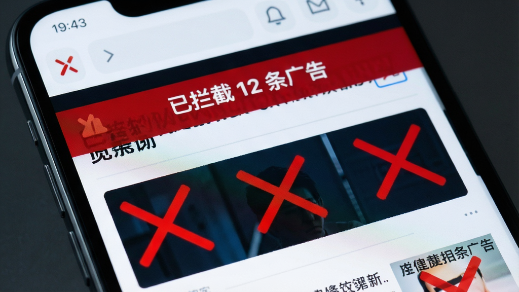 一部手机屏幕显示X浏览器正在拦截网页广告的界面,页面上方有“已拦截 12 条广告”的提示,背景是新闻网页,广告区域被红色叉号标记屏蔽,整体风格科技感十足,布局清晰,画质高清,无多余元素