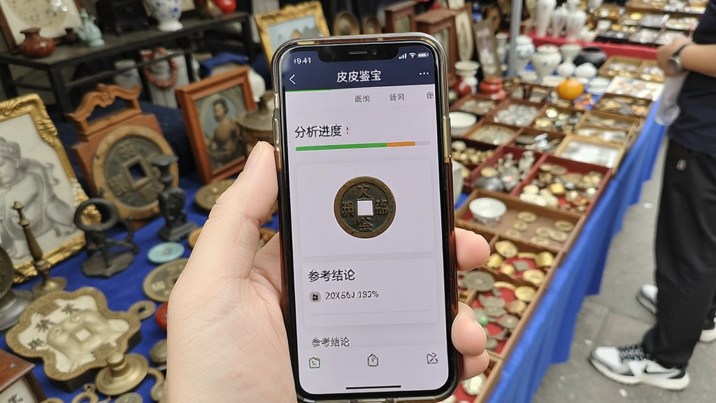 一部手机握在手中,镜头对准一枚古钱币,手机屏幕显示皮皮鉴宝识别结果页面,页面中有分析进度条和参考结论,背景为古玩市场摊位,风格写实,光线明亮,画质清晰,干净,无多余元素,屏幕中显示