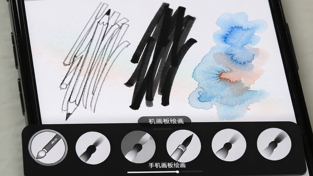手机屏幕特写,画布上同时呈现铅笔细线、马克笔粗线与水彩晕染三种笔触效果,屏幕下方弹出笔刷选择面板,面板上有多个圆形笔刷图标,整体风格清爽简洁,画质干净,文字标签为“手机画板绘画”