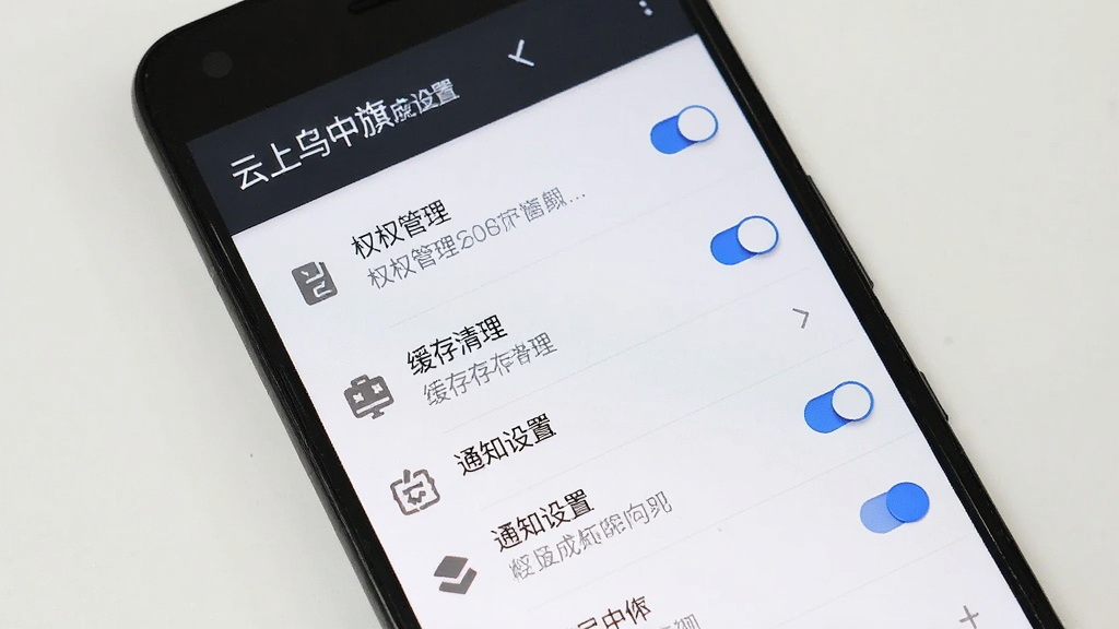 一部安卓手机屏幕显示“云上乌中旗”应用设置页面,主体为手机正面特写,布局上包含权限管理、缓存清理、通知设置等列表项,排版纵向排列,风格简洁实用,细节包含蓝色开关按钮和灰色图标,画质清晰,画面干净,无多余元素