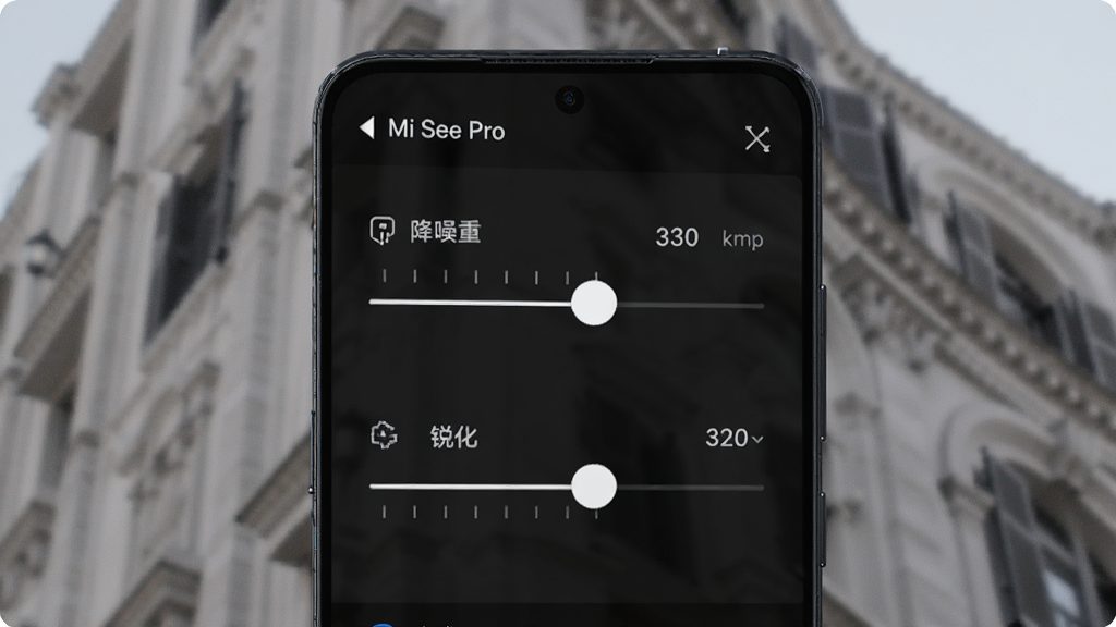手机屏幕展示 Mi See Pro 的细节调节界面,画面中有降噪与锐化两个滑杆控件,背景为一张建筑纹理照片的局部放大图,界面顶部显示软件名“Mi See Pro”,风格偏向工具型深色主题,细节上突出滑杆刻度与数值标签,画质清晰,干净无多余元素