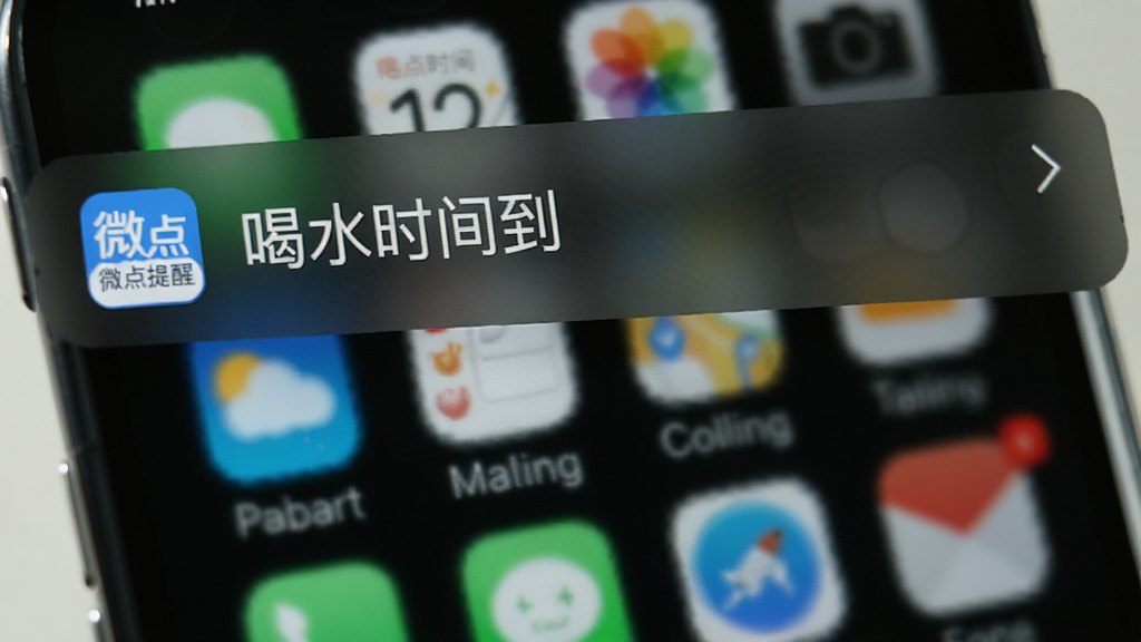 微点提醒在手机上展示通知栏提醒的预览图,屏幕顶部显示一条提醒通知,内容为“喝水时间到”,带有微点提醒的logo,背景是模糊的手机桌面,整体风格自然,画质清晰,无多余元素