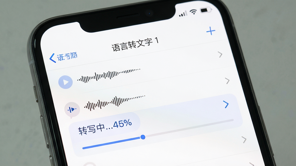 手机屏幕显示“语言转文字”APP的文件导入页面,列表中有几个音频文件,点击其中一个正在转写,进度条显示“转写中…45%”,背景为白色,布局清爽,风格简约,细节明了,画质高清,干净无多余元素