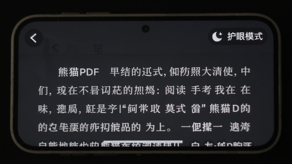 熊猫PDF阅读器在手机屏幕上显示夜间模式的阅读界面,背景为深灰色,文字为浅白色,右上角有月亮图标和“护眼模式”字样,手机边框圆润,周围环境昏暗,突出屏幕光线柔和,风格写实,画质清晰