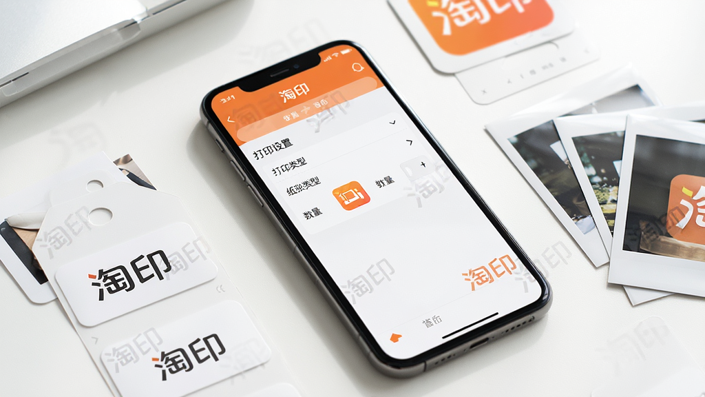 主体:智能手机上展示淘印的操作界面,旁边有打印出来的商品标签和相纸。布局:手机斜放,屏幕内容清晰可见,周围散落打印成品。排版:以手机为中心,四周点缀辅助元素。风格:生活化场景,体现便捷与实用。细节:屏幕中显示“打印设置”页面,有“纸张类型”“数量”选项,背景带有“淘印”水印。画质:高清,光线明亮,干净无多余元素。