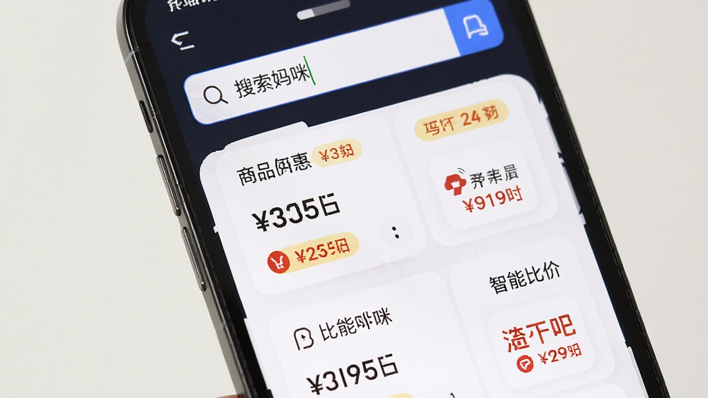 省钱妈咪 智能比价功能界面,主体为手机屏幕特写,屏幕中展示搜索框输入商品名称后出现的价格对比列表,布局为上下排列的卡片式结构,排版清晰,风格现代简约,细节有价格数字、优惠标签、平台图标,画质干净,无多余元素