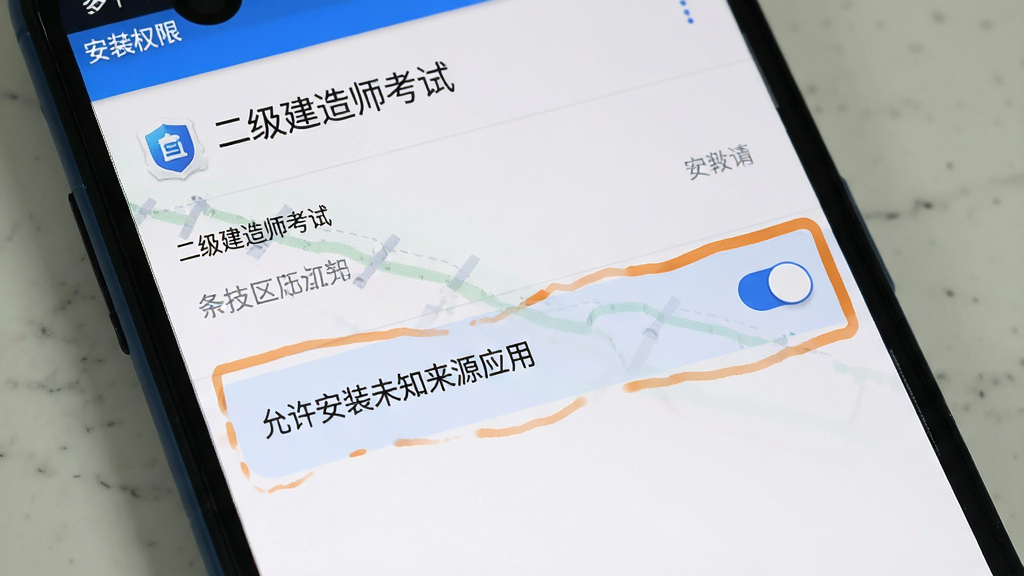 一张展示安卓手机屏幕的图片,屏幕上显示“二级建造师考试”APP的安装权限设置界面,高亮标注出“允许安装未知来源应用”的开关按钮,画面风格为系统界面截图风格,清晰展示操作步骤,背景简洁,无多余元素