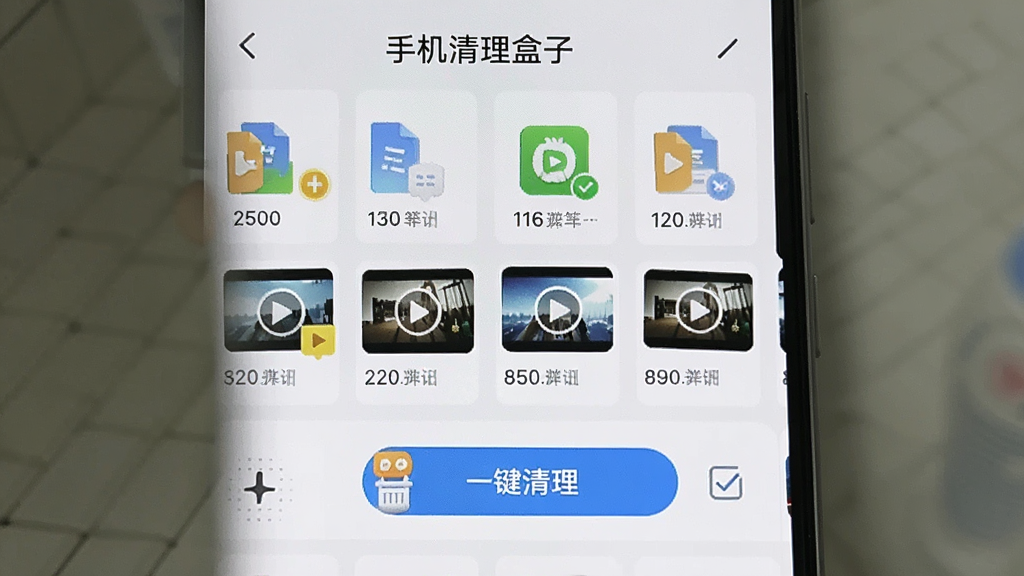 手机屏幕显示“手机清理盒子”的微信专清界面,界面中列出了一排排聊天记录文件图标与视频缩略图,每个文件旁标注了占用空间大小,主体为手机应用界面,布局清晰,风格简洁明亮,细节包含“一键清理”按钮与勾选框,画质清晰,干净,无多余元素