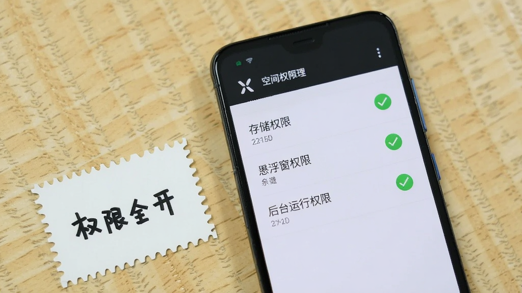 一部安卓手机屏幕显示X空间的权限管理页面,页面中列出存储权限、悬浮窗权限、后台运行权限三项,每项右侧有绿色勾选标记,手机旁边放着一张写有