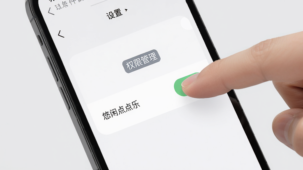 一部手机屏幕上显示悠闲点点乐的设置页面,旁边有手指正在点击权限开关,背景是浅灰色,画面中有“权限管理”的文字标签,风格简洁清晰,画质干净无多余元素