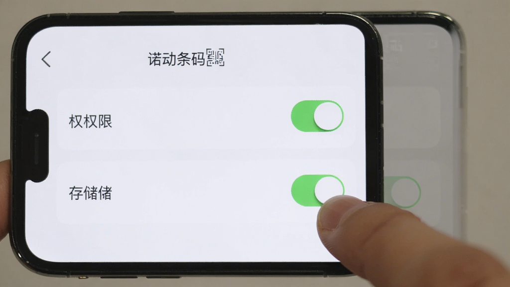 主体为手机屏幕显示“诺动条码”设置页面,布局采用竖屏正面展示,排版上权限开关和存储选项清晰可见,风格为清爽浅色UI风格,细节上手指正在点击相机权限开关,画质清晰,干净,无多余元素