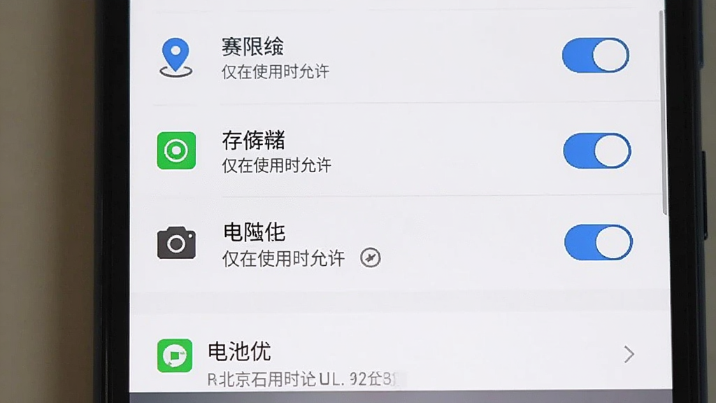 主体为一部安卓手机展示北京石景山APP的权限设置界面,布局上方为权限列表开关,下方为电池优化选项,排版清晰,风格为系统设置界面截图风格,细节包含定位、存储、相机权限图标与“仅在使用时允许”字样,画质清晰,干净无多余元素,画面中文字需包含“北京石景山”