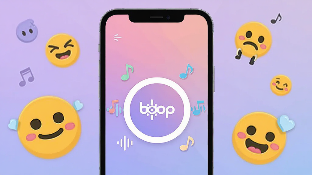 画面中央放置一部智能手机,手机屏幕亮起显示boop应用主界面,界面中央有一个巨大的圆形按钮,按钮周围环绕着音符和声波图标,背景是柔和的渐变紫色与粉色,手机两侧散落着可爱的卡通表情符号,整体风格活泼明快,扁平化设计,画质清晰干净,无多余元素